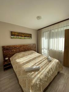 - une chambre avec un grand lit et une grande fenêtre dans l'établissement Borovets Gardens Ski Apartment, à Borovets