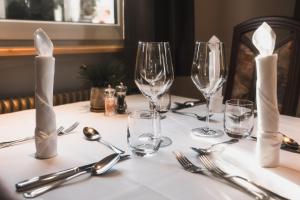 a table with empty wine glasses and silverware on it at Hotel Villa Waldheim in San Candido