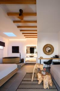 un dormitorio con una cama y una mesa en Olive Mykonos Villas, en Ano Mera