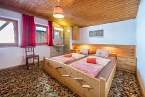 una camera con 2 letti e un soffitto in legno di Heiserhof App Birke a Val di Mezzo