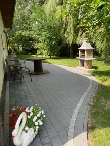 un patio con una statua di un coniglio e fiori di Apartamenty - Pod Wierzbami a Dwikozy