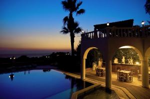 a villa with a swimming pool at night at Altinsaray Hotel in Kuşadası