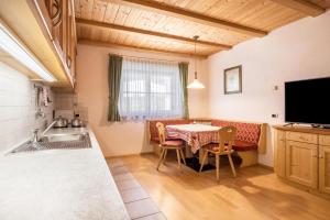 a kitchen and dining room with a table and chairs at App Lisüra Cir in Corvara in Badia