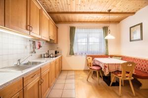 una cucina con tavolo e una sala da pranzo di App Lisüra Cir a Corvara in Badia