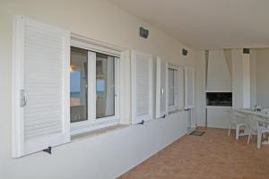 坎尼吉翁的住宿－La casa di Ziu Menicu，一间设有白色窗户和桌子的用餐室