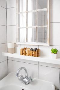 a white bathroom with a sink and a window at SK studios & apartments in Neo Klima