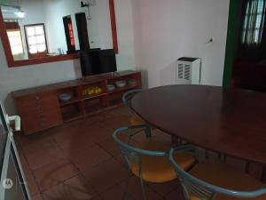 jadalnia ze stołem, krzesłami i telewizorem w obiekcie Hosteria La Farfalla w mieście Chos Malal