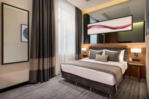a bedroom with a bed and a large window at Ramada by Wyndham Budapest City Center in Budapest