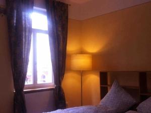 a bedroom with a window and a bed and a lamp at Das Gaestehaus in Offenburg