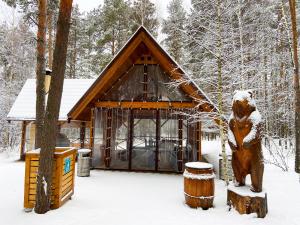 喀山的住宿－Irbis Hotel，雪中小屋前的熊雕像