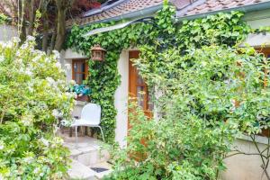 una silla blanca sentada en el porche de una casa en Studio avec jardin clos et wifi a Ville d'Avray a 1 km des pistes, en Champs-Sur-Marne