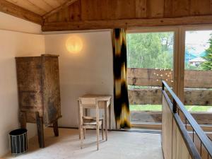 um quarto com uma mesa de madeira e uma janela em Stalla d' Immez em Sta Maria Val Müstair