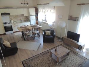 a living room with a table and a kitchen at Διαμέρισμα με κήπο in Orestiada