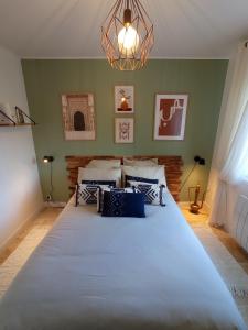 ein großes Bett in einem Zimmer mit grünen Wänden in der Unterkunft Maison Bohème Vesubie in La Bollène-Vésubie