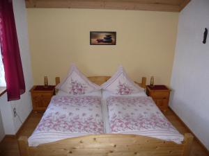 1 dormitorio con 1 cama de madera y 2 almohadas en Ferienwohnung Eder, en Mauth