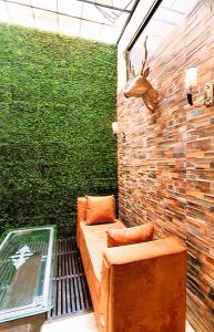 a patio with a couch and a green wall at The Buddhayan Villa in Jaipur