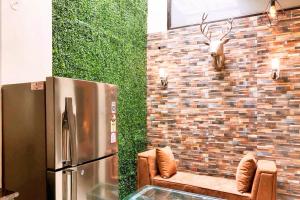 a room with a refrigerator and chairs and a brick wall at The Buddhayan Villa in Jaipur