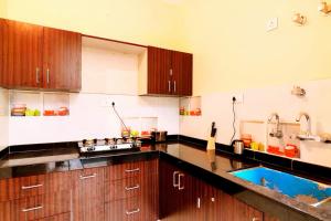 a kitchen with wooden cabinets and a blue sink at The Buddhayan Villa in Jaipur