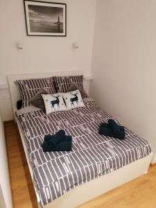 a bed in a room with two pillows on it at Blue Zet Apartament in Sarbinowo