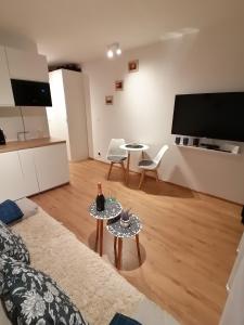 a living room with two tables and a flat screen tv at Blue Zet Apartament in Sarbinowo