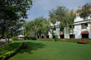 a courtyard of a building with a lawn and trees at Trident Chennai in Chennai