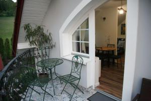 a balcony with a table and chairs on a house at Domek i Apartamenty Zacisze in Brenna