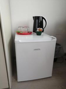 a white refrigerator with a coffee pot on top of it at Rooms Izola in Izola