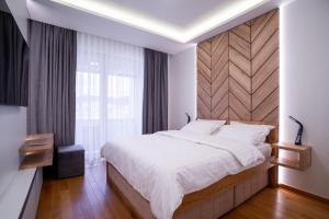1 dormitorio con 1 cama grande y cabecero de madera en Apartman G8 Deluxe en Pale