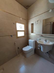 bagno con servizi igienici, lavandino e finestra di Omani House Inn نزل البيت العماني a Nizwa