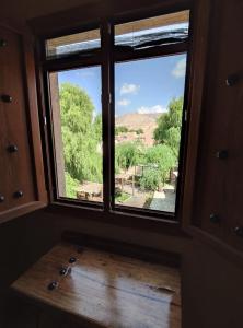 ニズワにあるOmani House Inn نزل البيت العمانيの野原の景色を望む部屋の窓