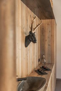 a bathroom with a sink with a deer head on the wall at Das Liftplatzl in Sankt Michael im Lungau