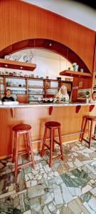 Hřiměždice的住宿－Penzion a restaurace U jezírka，酒吧里带三把凳子的餐厅