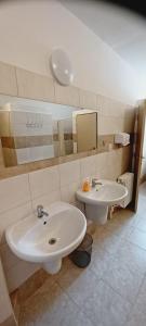 a bathroom with two sinks and a mirror at Penzion a restaurace U jezírka in Hřiměždice
