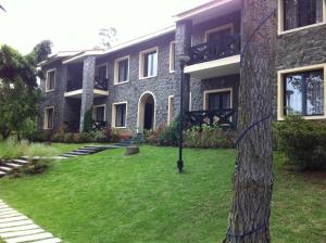 a building with a grass yard in front of it at Green Pastures - A Hill Country Resort in Kodaikānāl