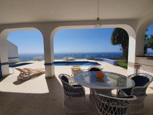 een patio met een tafel en stoelen en een zwembad bij Villa Tango in Salobreña