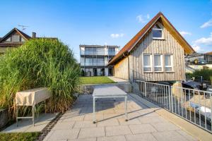 un banco sentado en un patio frente a una casa en Fewo Willam, en Allensbach