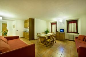 a kitchen and living room with a table and chairs at Residence Deborah in Madesimo