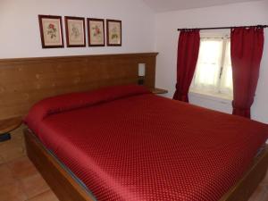 a red bed in a bedroom with a window at Residence Deborah in Madesimo