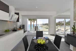 a kitchen with a table with a bowl of fruit on it at Apartment Nueva Suecia CR715 by VillaGranCanaria in San Agustin +31 photos