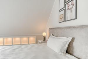 a bedroom with a bed with a white pillow at One Moment Boardinghouse - Porta Westfalica in Porta Westfalica +75 photos