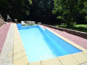 a large blue swimming pool with a table and chairs at Dworek Leśny in Kudowa-Zdrój