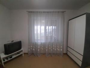 a living room with a tv and a window at Загородный дом на берегу реки Самара in Dnipro