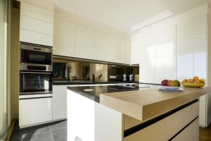 a kitchen with white cabinets and a counter with fruit on it at 3-Br apartment exceptional sea view by the beaches in Cannes