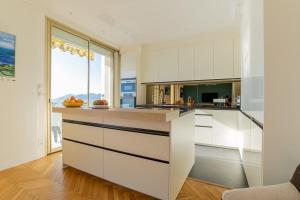 a kitchen with white cabinets and a large window at 3-Br apartment exceptional sea view by the beaches in Cannes