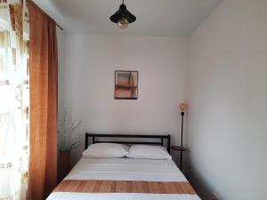 a bed in a room with a white wall at Загородный дом на берегу реки Самара in Dnipro