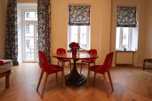 a dining room with a table and red chairs at Wohnung mit Balkon beim Schloss Belvedere in Vienna