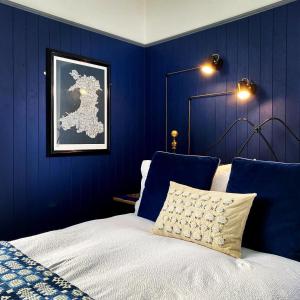 een slaapkamer met blauwe muren en een bed met een kussen bij Crafnant House - Bed & Breakfast in Trefriw