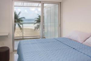a bedroom with a bed and a view of the beach at Asturias Mall & Suítes in Guarujá