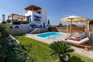 een villa met een zwembad en een huis bij Villa Rose on the beach in Afantou