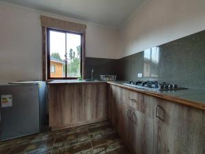 Una cocina vacía con una estufa y una ventana. en Cabañas Olas del Bosque, en Pichilemu